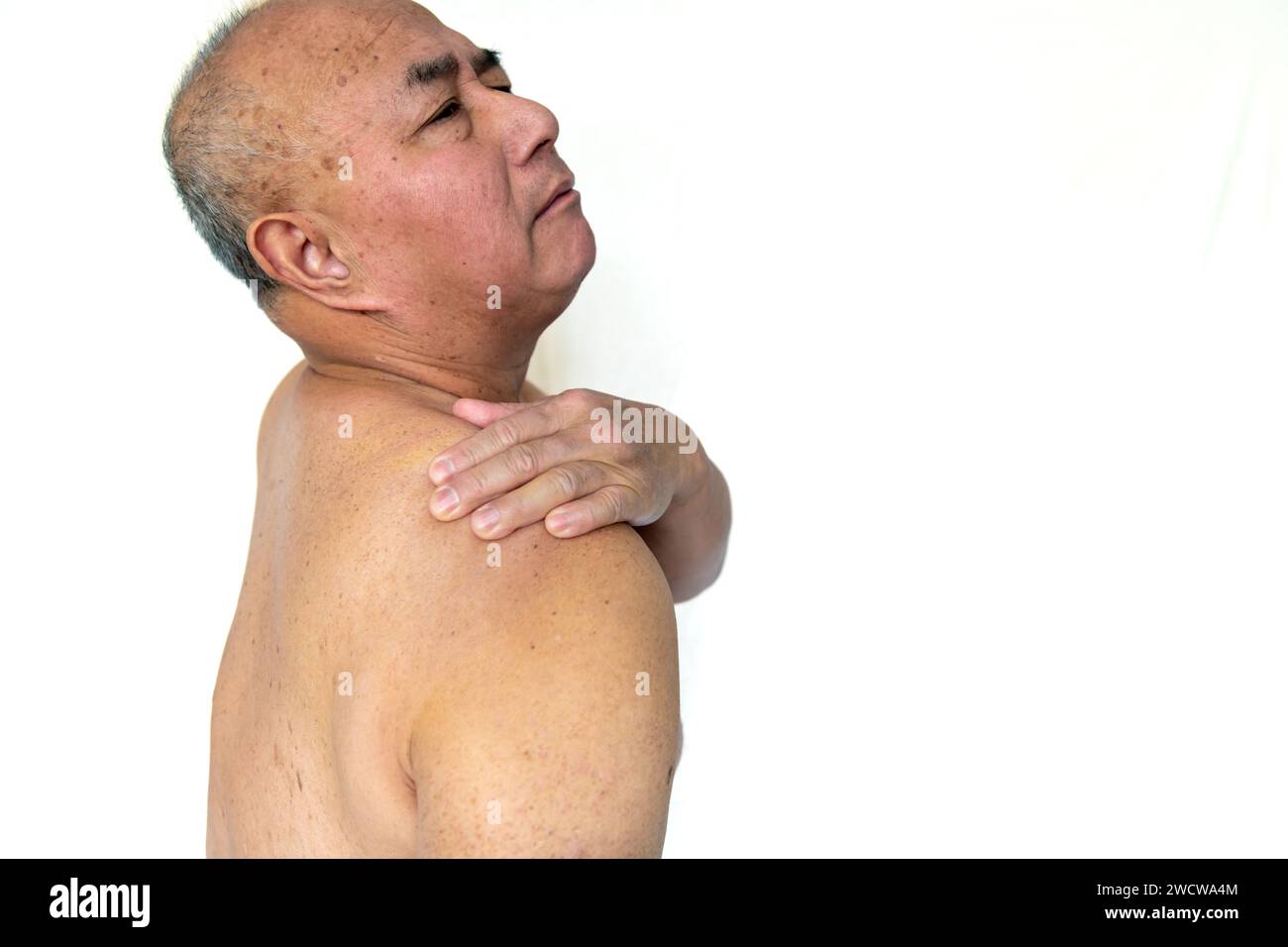 A senior man suffering from pain in the shoulder isolated in a white background Stock Photo