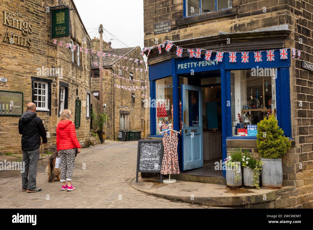 UK, England, Yorkshire, Worth Valley, Haworth, visitors outside Pretty-Penny clothes shop at junction with West Lane and Changegate, Stock Photo