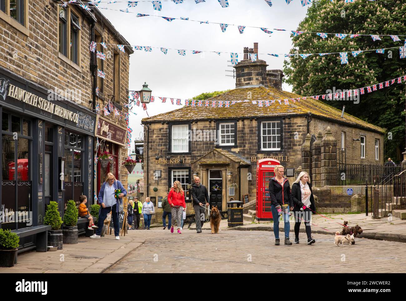 UK, England, Yorkshire, Worth Valley, Haworth, visitors below bunting at junction with Main Street and Changegate, Stock Photo