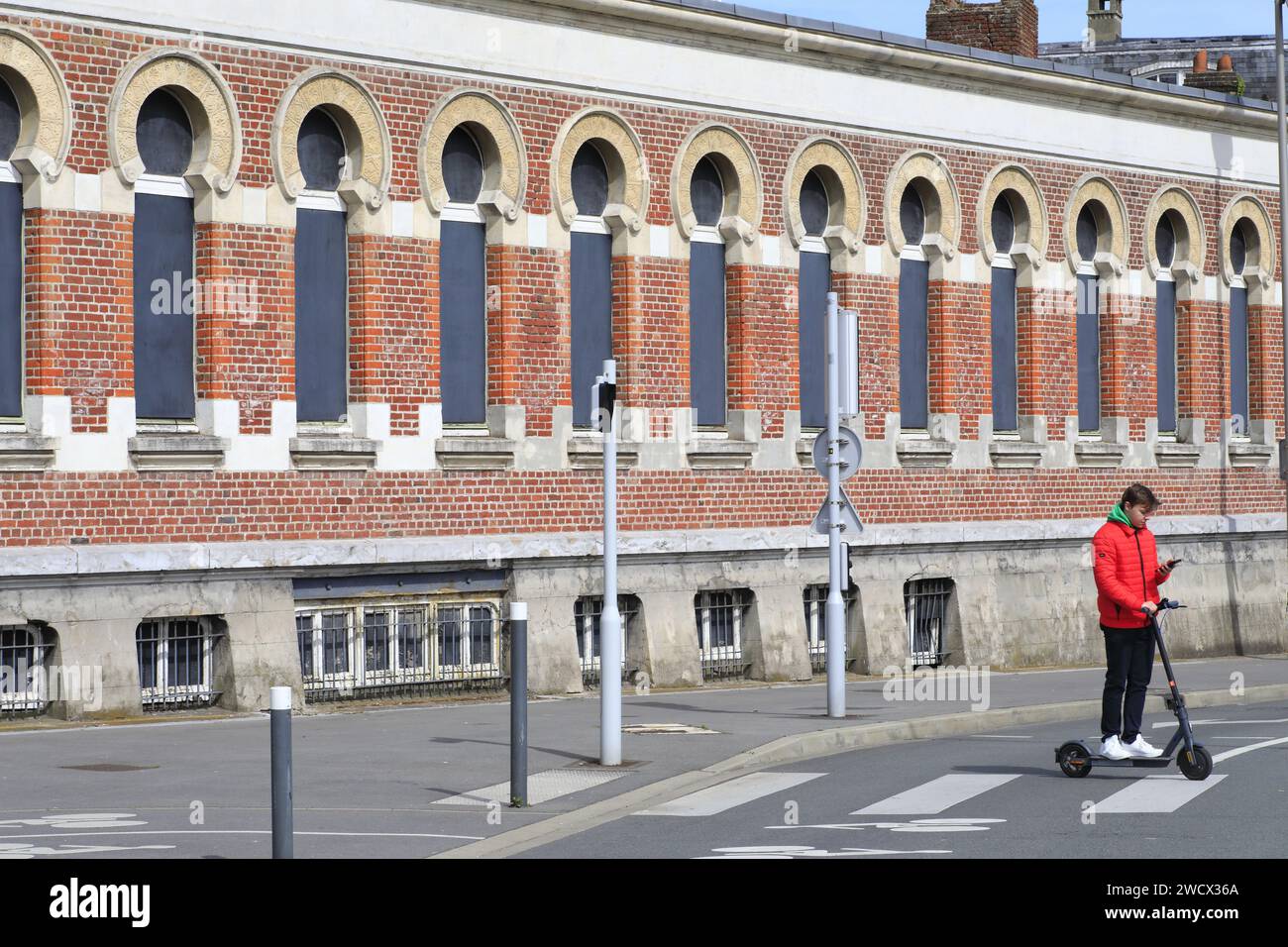 France, Nord, Dunkirk, scooter on the pedestrian crossing in front of the former Bains Dunkerquois (1896) in Moorish style according to the plans of architects Louis Gilquin, Charles Boidin and Albert Baert with swimming pool, wash houses, bathtubs... Stock Photo