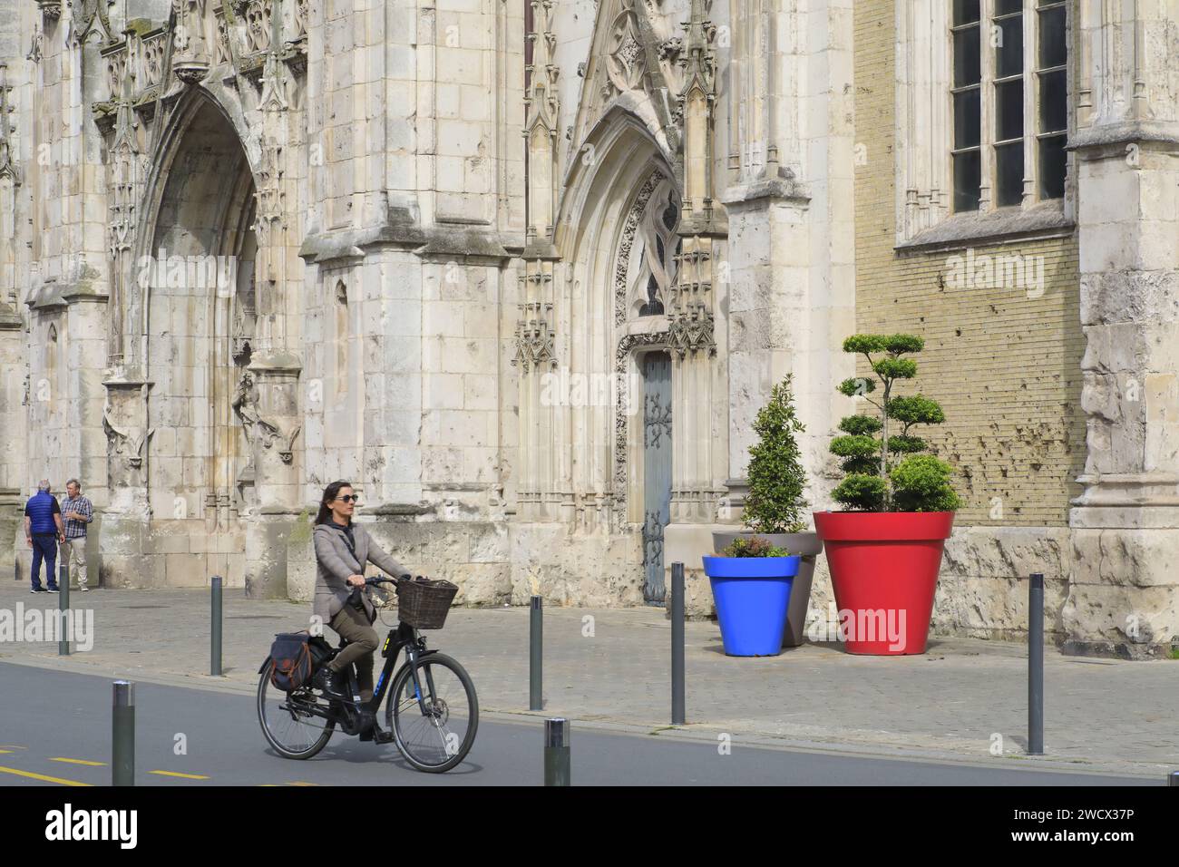 France, Nord, Dunkirk, Saint-Éloi church, cyclist in front of the late 19th century facade with bomb impacts from the Second World War Stock Photo