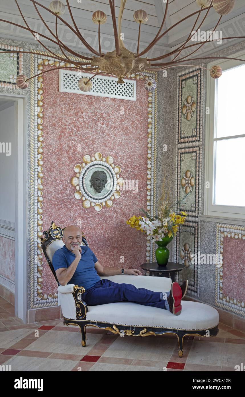 Portugal, Alentejo, Melides, the shoe designer Christian Louboutin lying on a chaise longue in a corridor decorated with trompe l'oeil paintings in his boutique hotel Vermelho Stock Photo