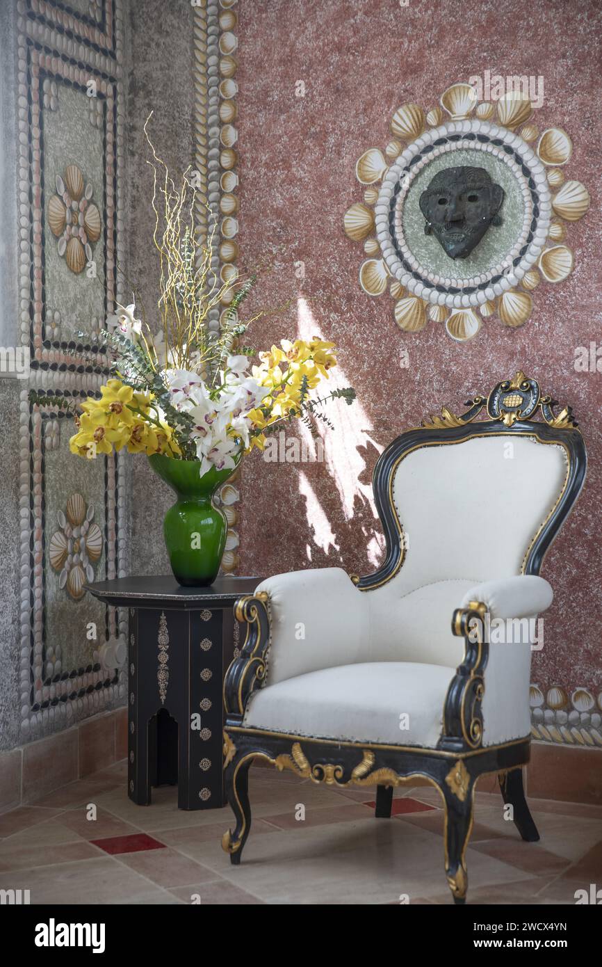 Portugal, Alentejo, Melides, bouquet of flowers and Empire style armchair in a corridor decorated with trompe l'oeil paintings of the Vermelho boutique hotel owned by shoe designer Christian Louboutin Stock Photo
