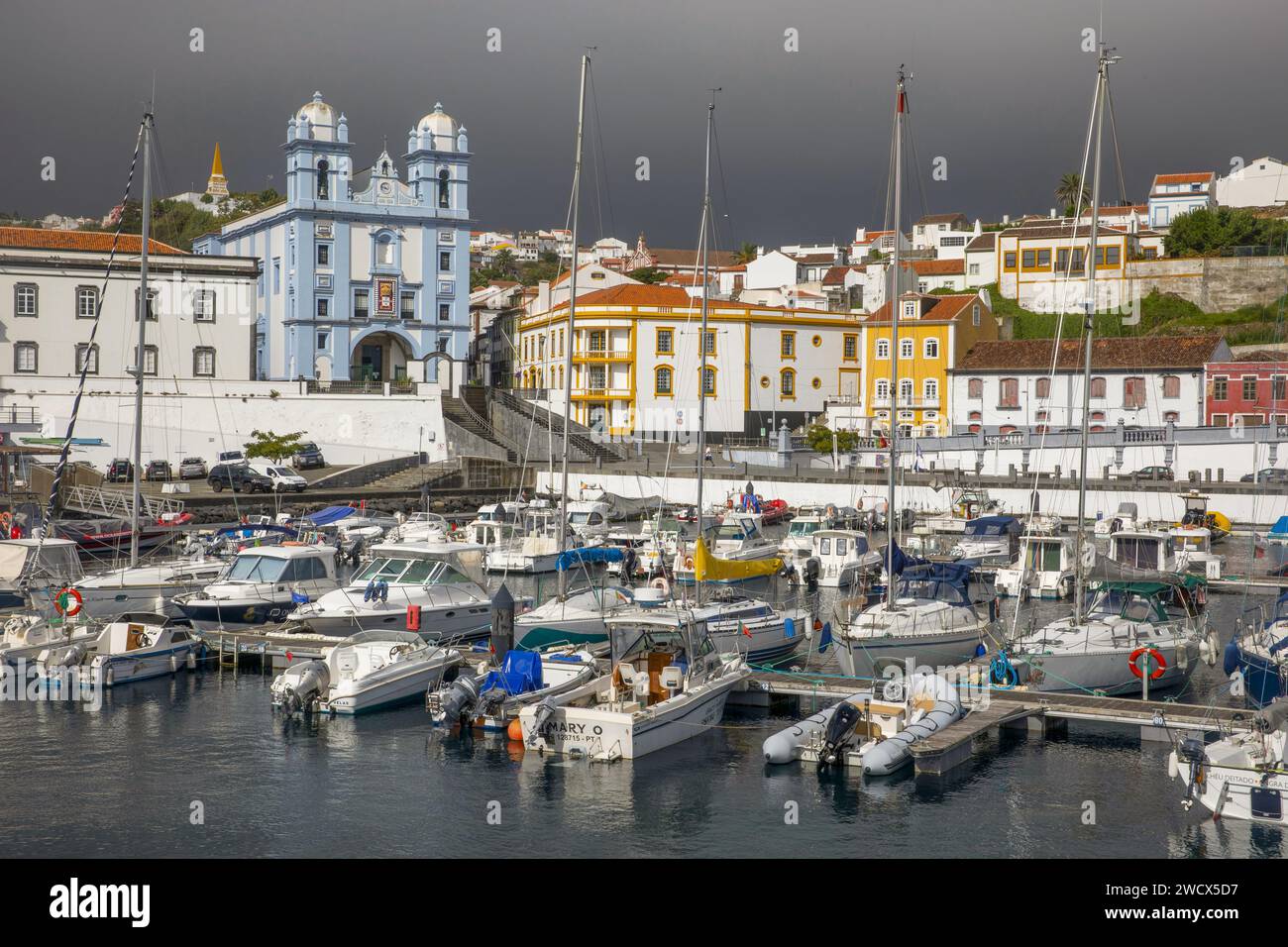 Portugal, Azores archipelago, Terceira island, Angra do Heroismo, port welcoming pleasure boats with the Church of Mercy painted in azure blue and colorful colonial buildings Stock Photo