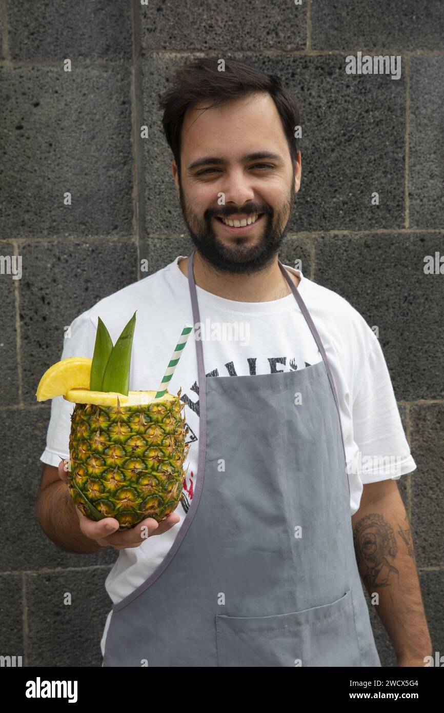 Portugal, Azores archipelago, Sao Miguel island, Ponta Delgada, street seller holding a pineapple in his hands Stock Photo