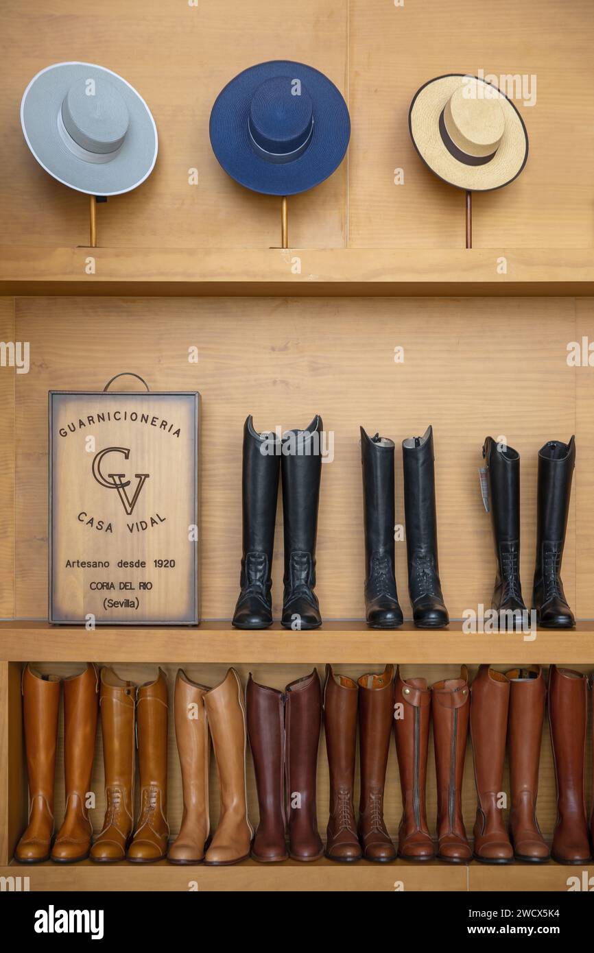 Spain, Andalusia, Coria del Rio, Andalusian rider's boots and hats placed on shelves of the century-old Casa Vidal saddlery Stock Photo