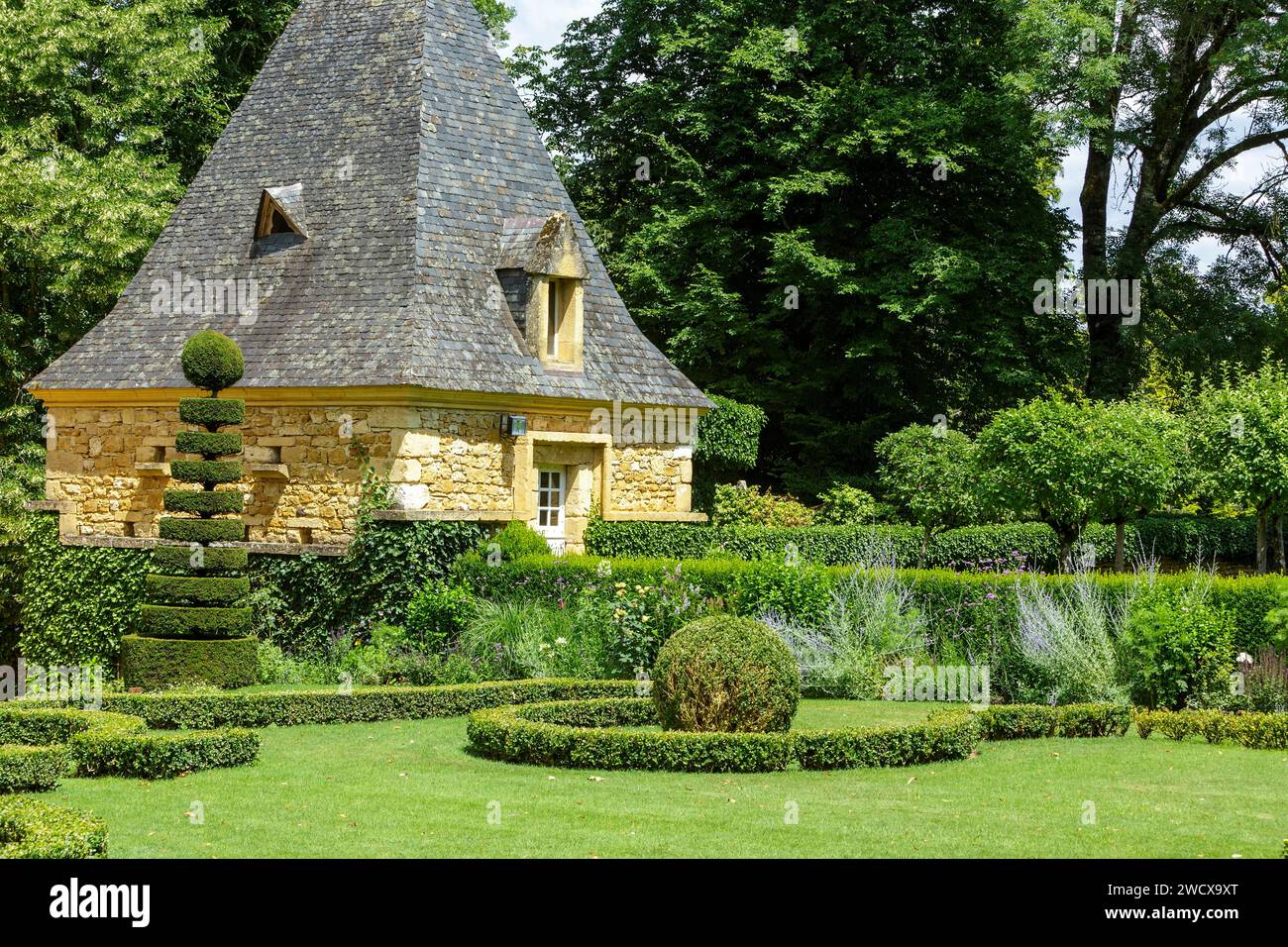 France, Dordogne, Perigord Noir, Salignac eyvigues, the gardens of the Manoir d'Eyrignac labelled Jardins Remarquables (remarkable gardens) recomposed in the 20th century based on italian gardens of the Renaissance, gardens A La Francaise of the 18th century, medieval gardens with country style gardens on the outskirts, outbuilding of the manor, trees and boxwoods Stock Photo