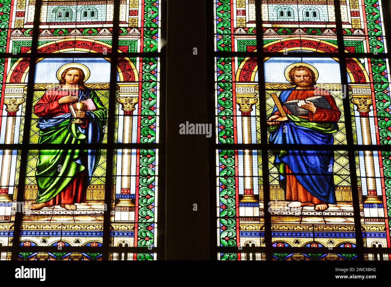 France, Meurthe et Moselle, Nancy, Saint Mansuy church built between 1878 and 1881 by architect Emile Jacquemin after the plans of his father Claude Jacquemin in neo romanesque style, stained glass window made by A. D. Issi a workshop in Munich which represents on the left Saint Jean the Evangelist with a chalice and a snake coming out from it, on the right Saint Thomas with a book and a square as patron saint of the architects, bricklayers, surveyors, stone masons, located Avenue de la LIberation Stock Photo