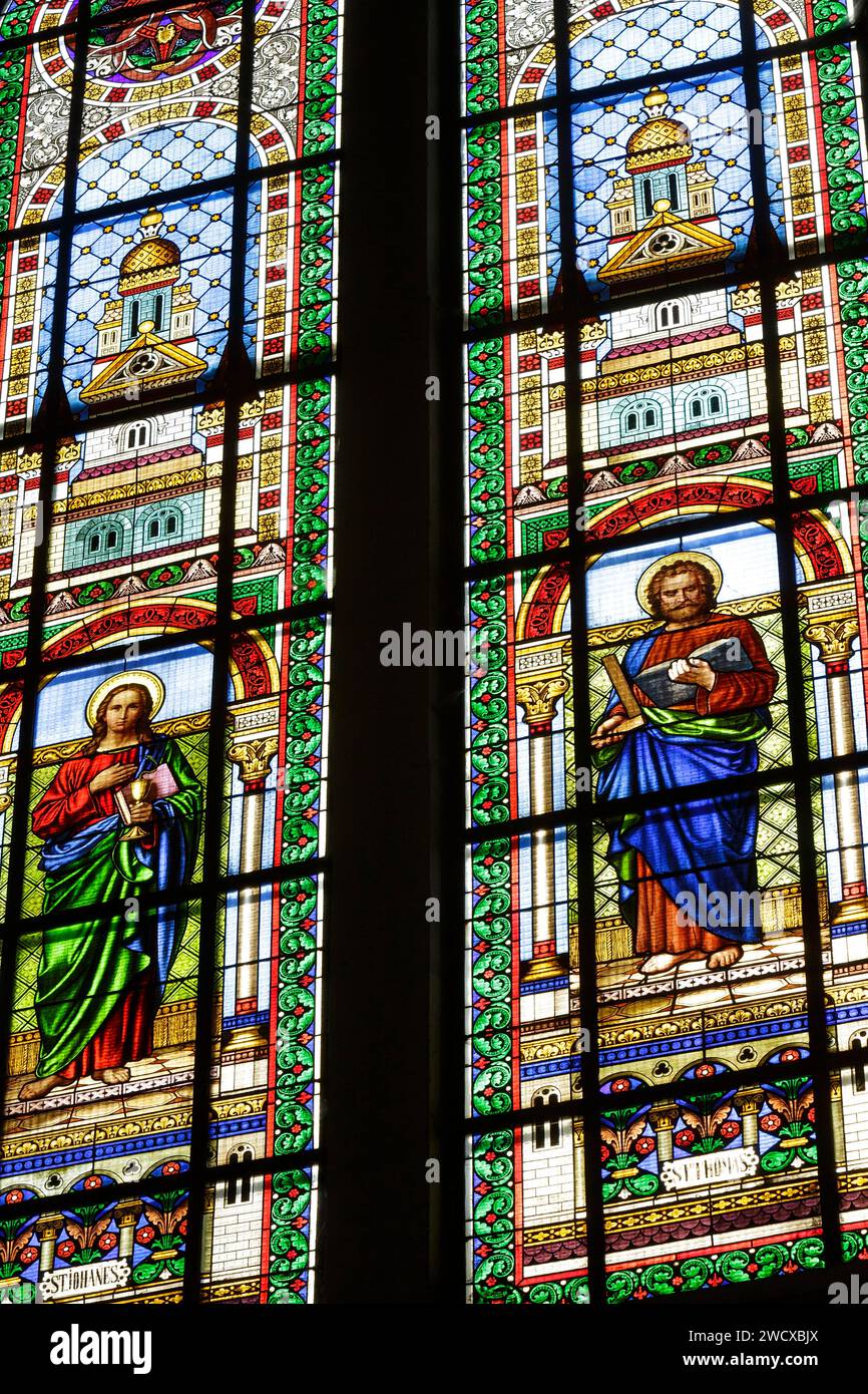 France, Meurthe et Moselle, Nancy, Saint Mansuy church built between 1878 and 1881 by architect Emile Jacquemin after the plans of his father Claude Jacquemin in neo romanesque style, stained glass window made by A. D. Issi a workshop in Munich which represents on the left Saint Jean the Evangelist with a chalice and a snake coming out from it, on the right Saint Thomas with a book and a square as patron saint of the architects, bricklayers, surveyors, stone masons, located Avenue de la LIberation Stock Photo