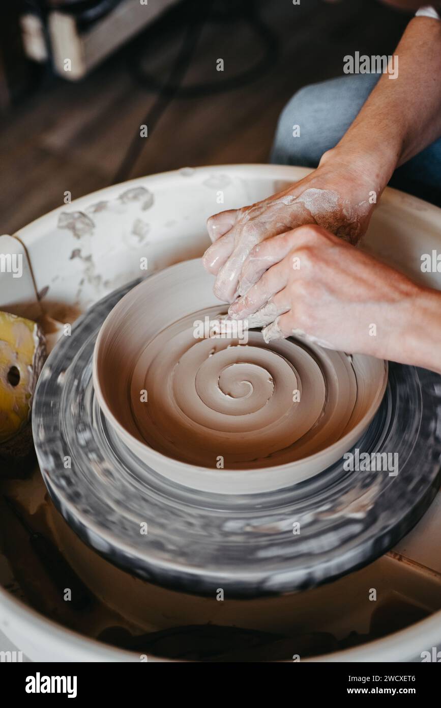 Decorating wet clay on potters wheel with a wine groove Stock Photo