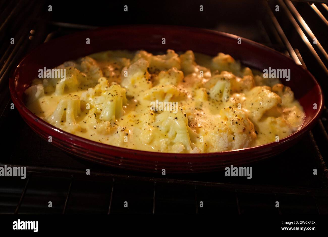 Home Cooking - Cauliflower Cheese cooking in an electric fan oven Stock Photo