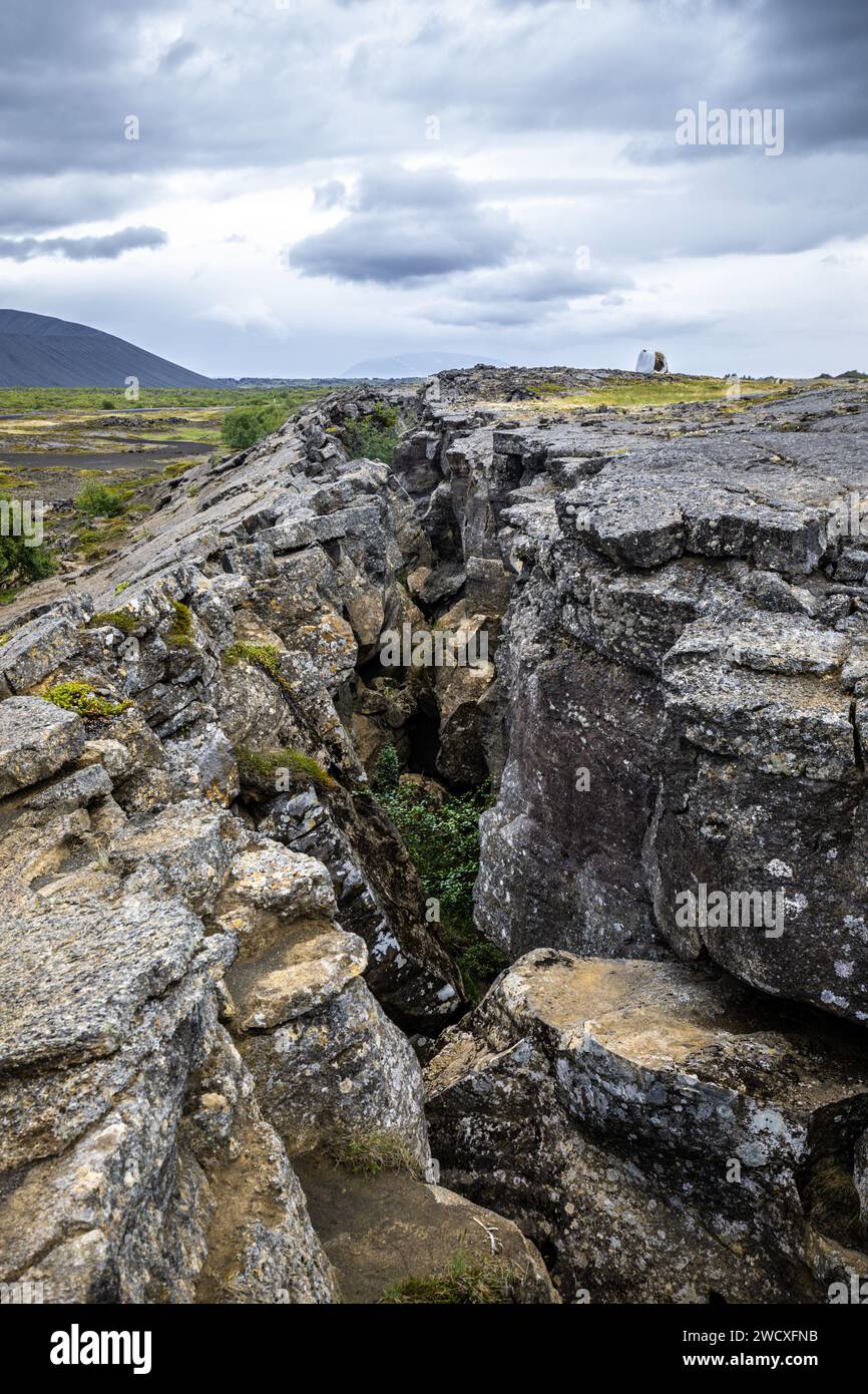 A deep fissure runs through the rocky crust of the fault zone of the Myvatn geothermal area in Iceland. Stock Photo