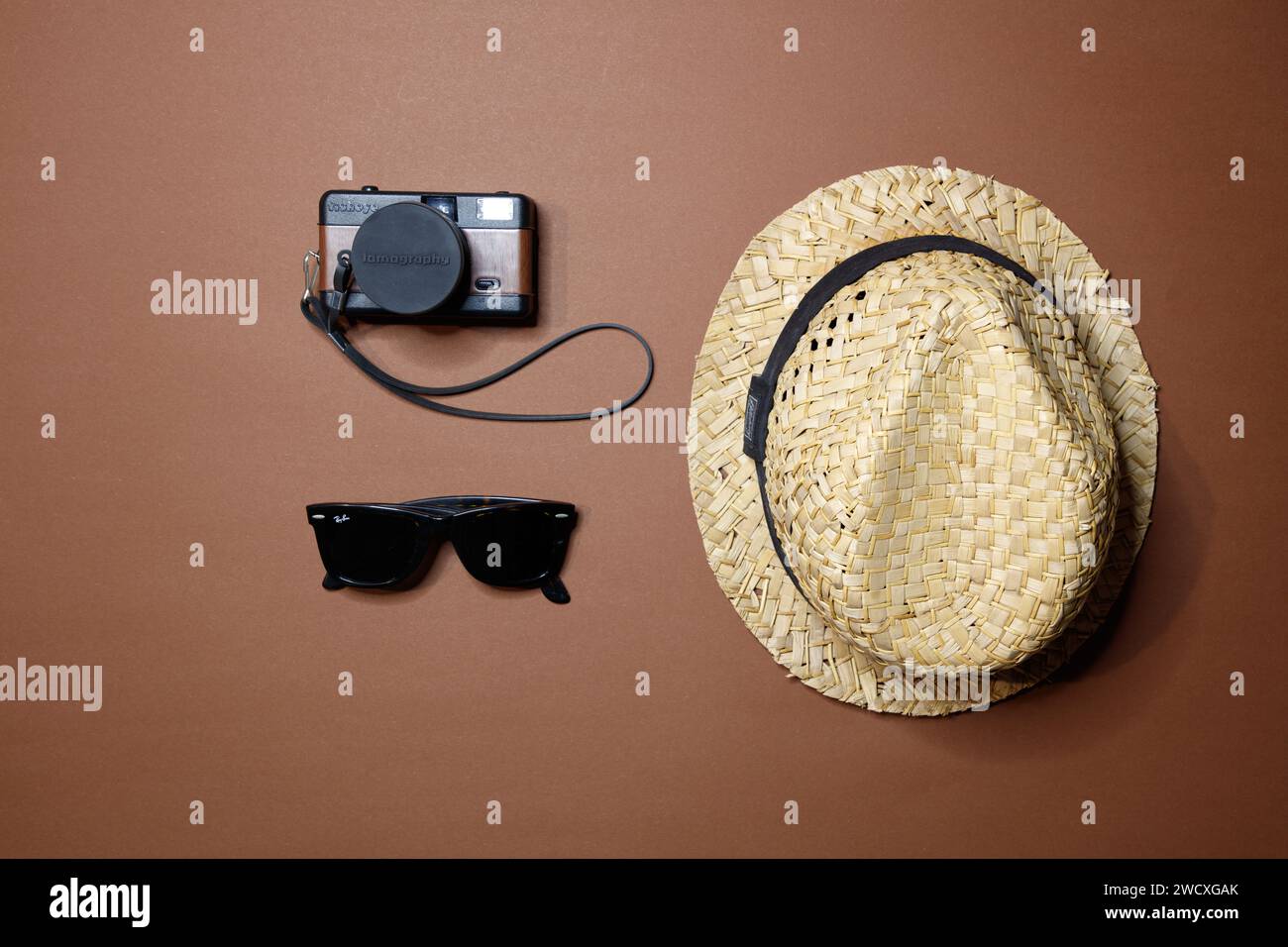 top view of a straw hat, Lomo film camera and rayban sunglasses, studio shot Stock Photo