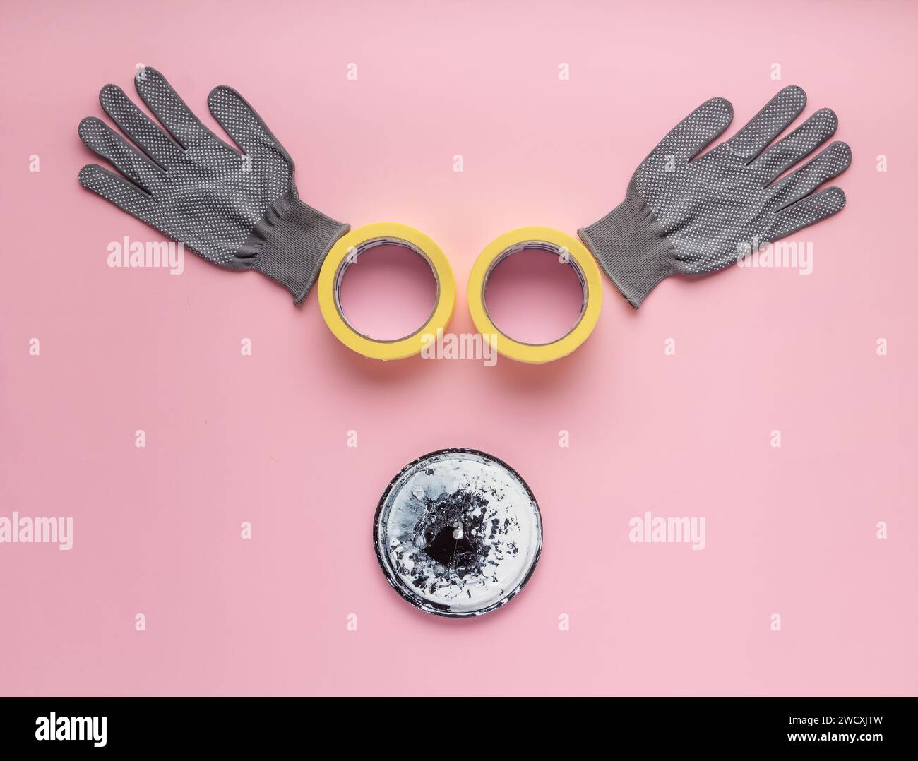 Creative composition with gloves, masking tape and paint cap on pink