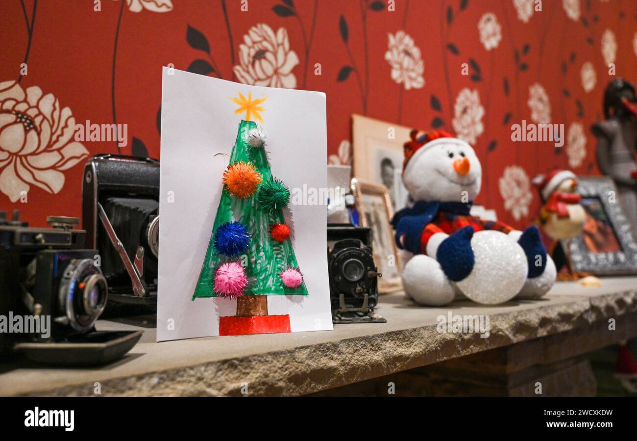 Hand made Christmas card and decorations on fireplace for festive season UK Stock Photo