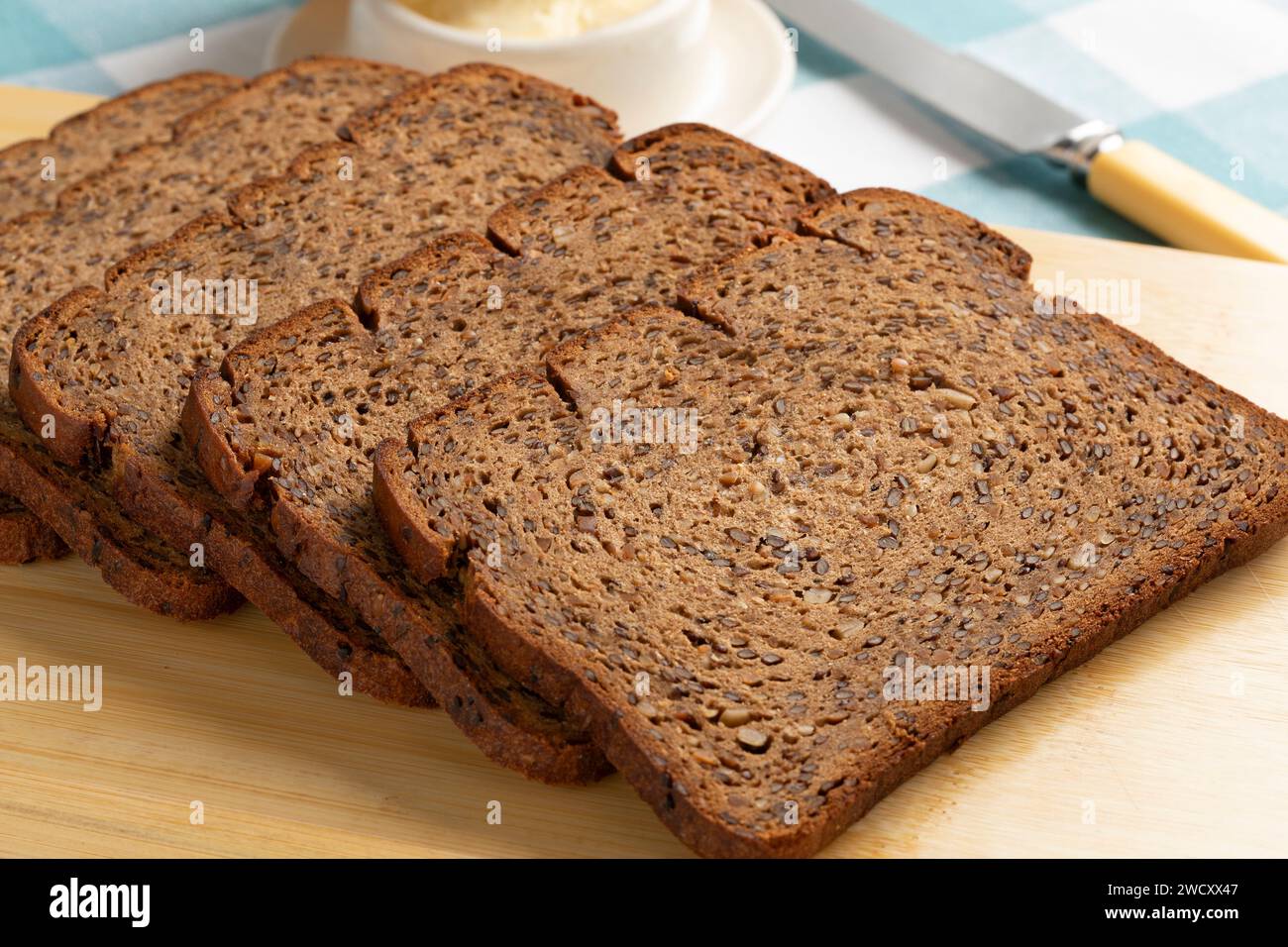 Thin slices of fresh baked brown linseed bread close up on a cutting board Stock Photo