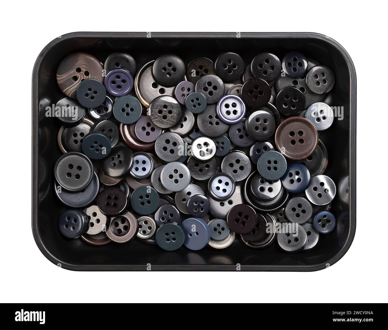 Plastic sew-through buttons, in a black plastic dish. Flat buttons with holes through which thread is sewn to attach the button. Fastener. Stock Photo