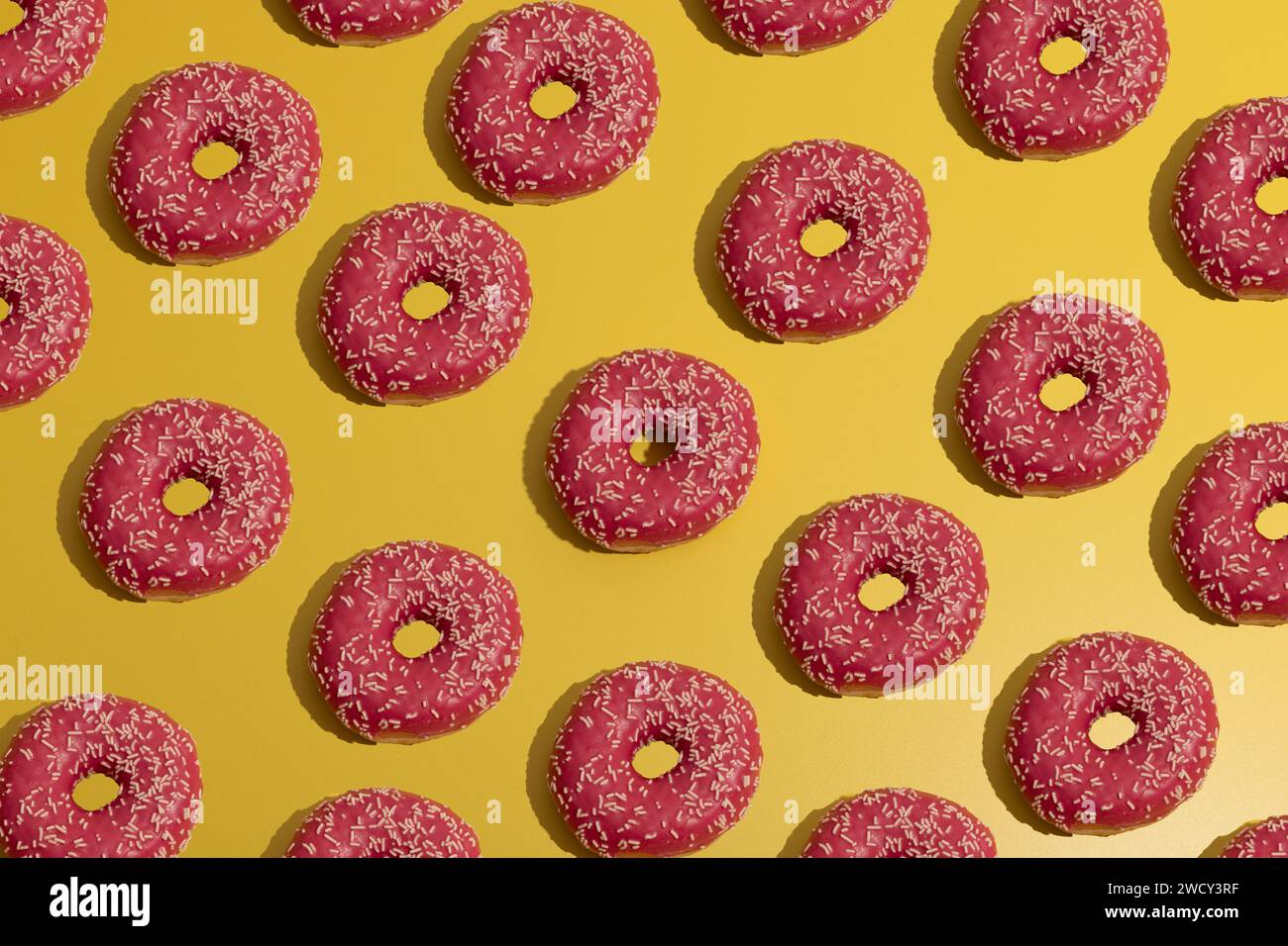 Flat lay image of pink donut repetitive pattern composition Stock Photo