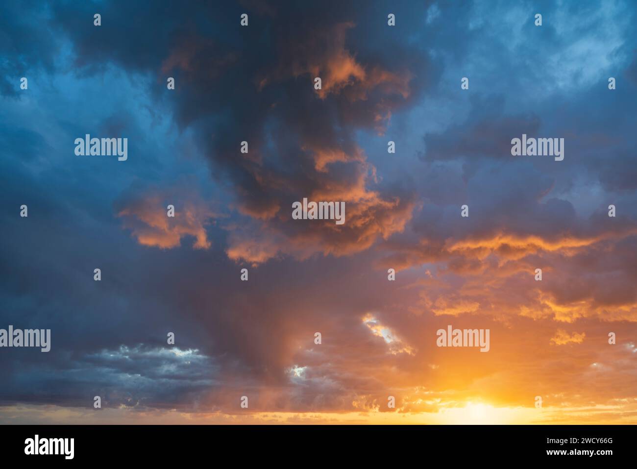 Glowing real sky at sunset texture background overlay. Dramatic red, orange, and purple clouds. High resolution photography perfect for sky replacemen Stock Photo