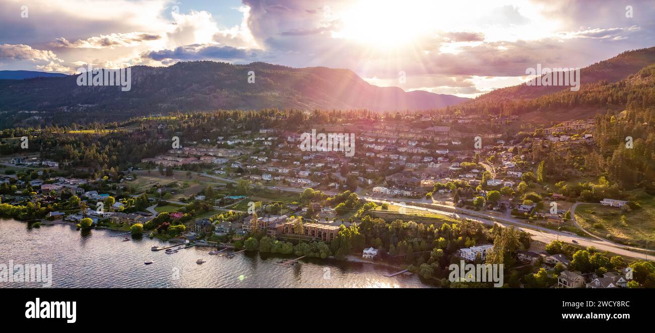 Small town on the hill near Okanagan Lake during a vibrant summer sunset. Stock Photo