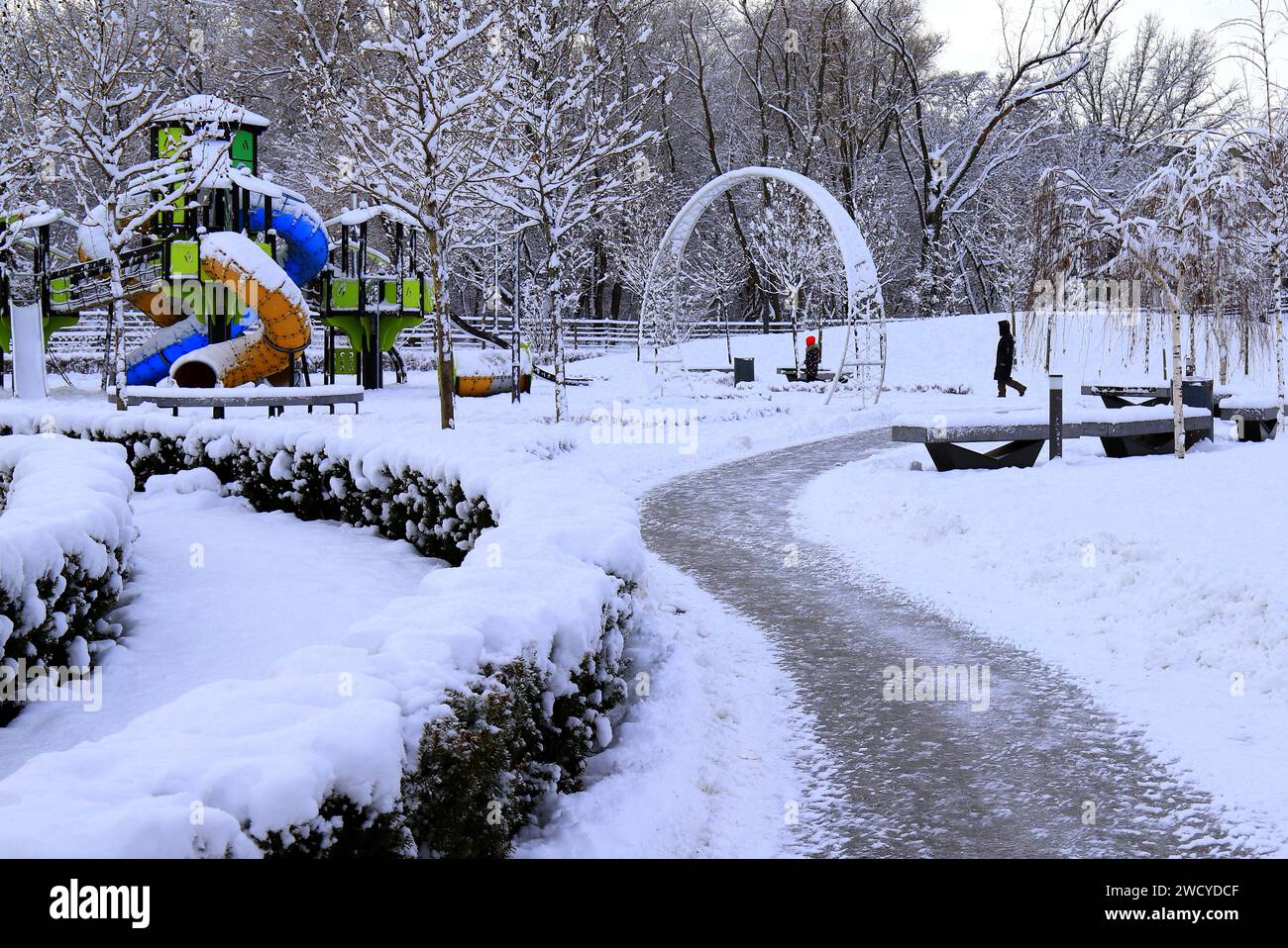 Winter park square street with children s playground, covered with snow. Children's slides and swings in winter. Dnipro, Ukraine Stock Photo