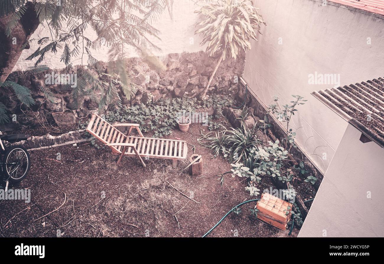 Aerial view of an old wooden lounger in a backyard, color toning applied. Stock Photo