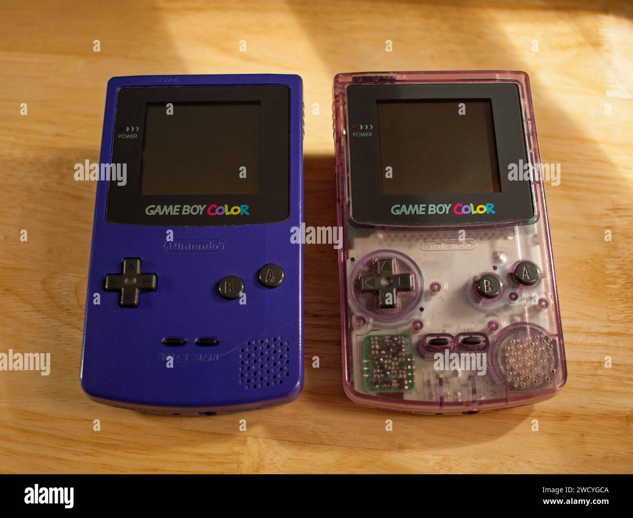 Miami, Florida, United States - November 26, 2023: Two vintage Nintendo Game Boy Color handheld games consoles. Color models Atomic Purple and Grape. Stock Photo