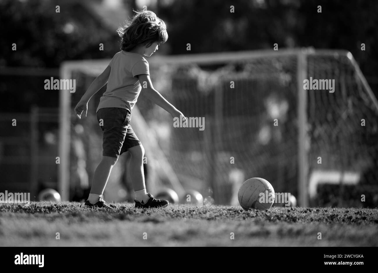 Boy child playing football on football field. Kid playing soccer ...