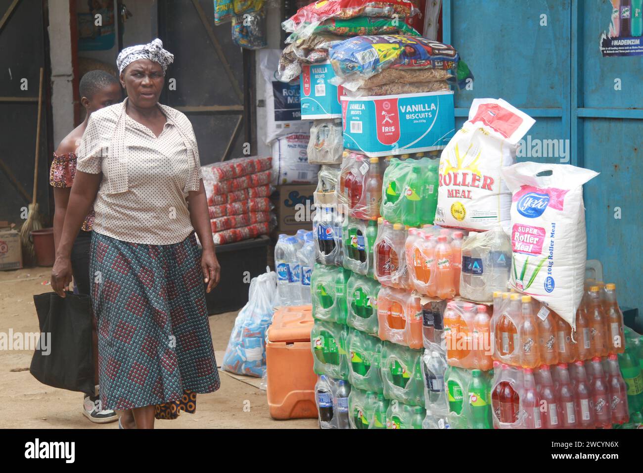 Harare, Zimbabwe. 16th Jan, 2024. People walk past a roadside grocery store in Harare, Zimbabwe, on Jan. 16, 2024. The cost of goods and services keeps on increasing in Zimbabwe as the local currency depreciates against the U.S. dollar, a trend that accelerated at the beginning of 2024. Credit: Tafara Mugwara/Xinhua/Alamy Live News Stock Photo