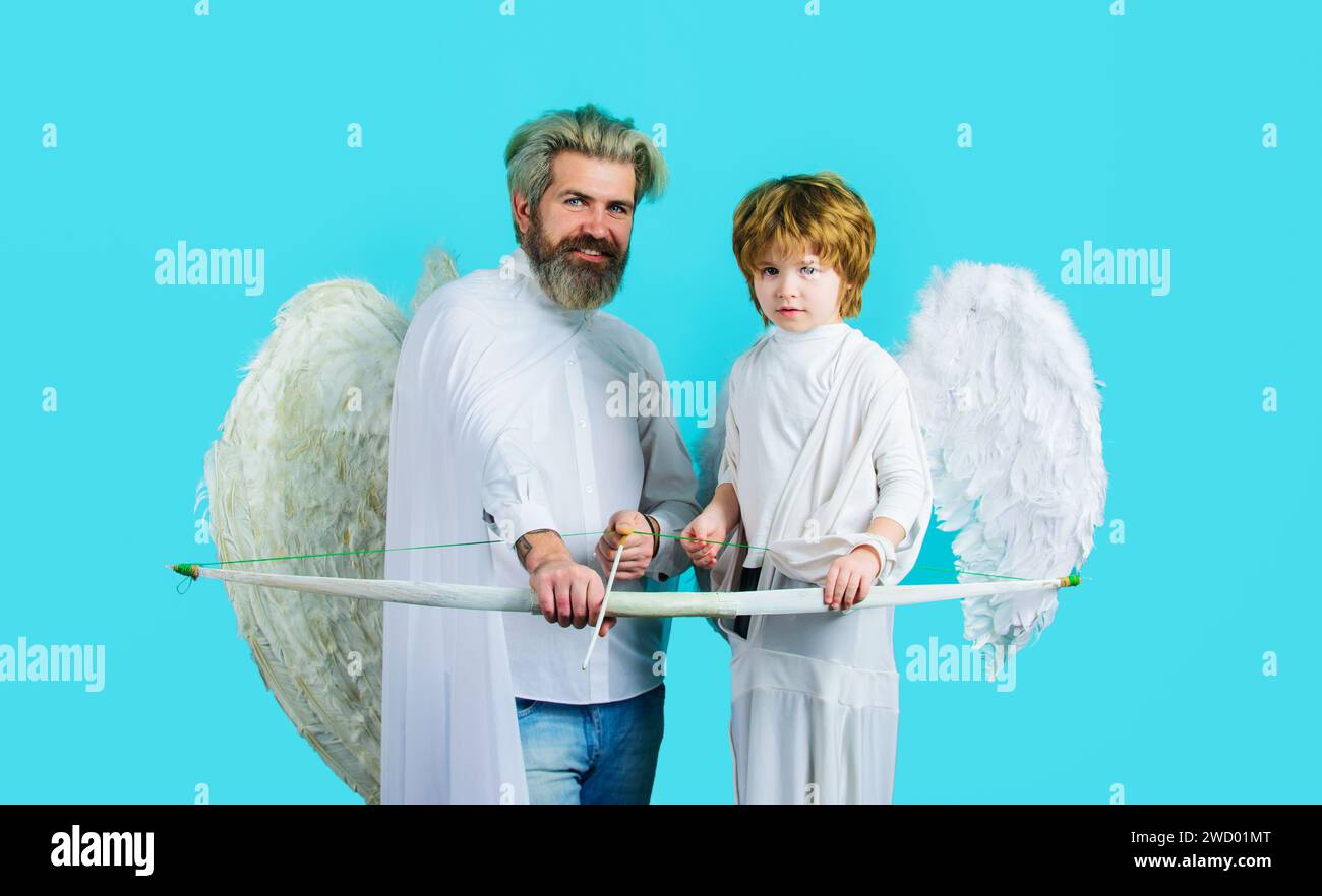 Valentines day celebration. Little boy and bearded man in angel costume with bow and arrow. Cute Christmas angels. Father's day. Father and son in Stock Photo