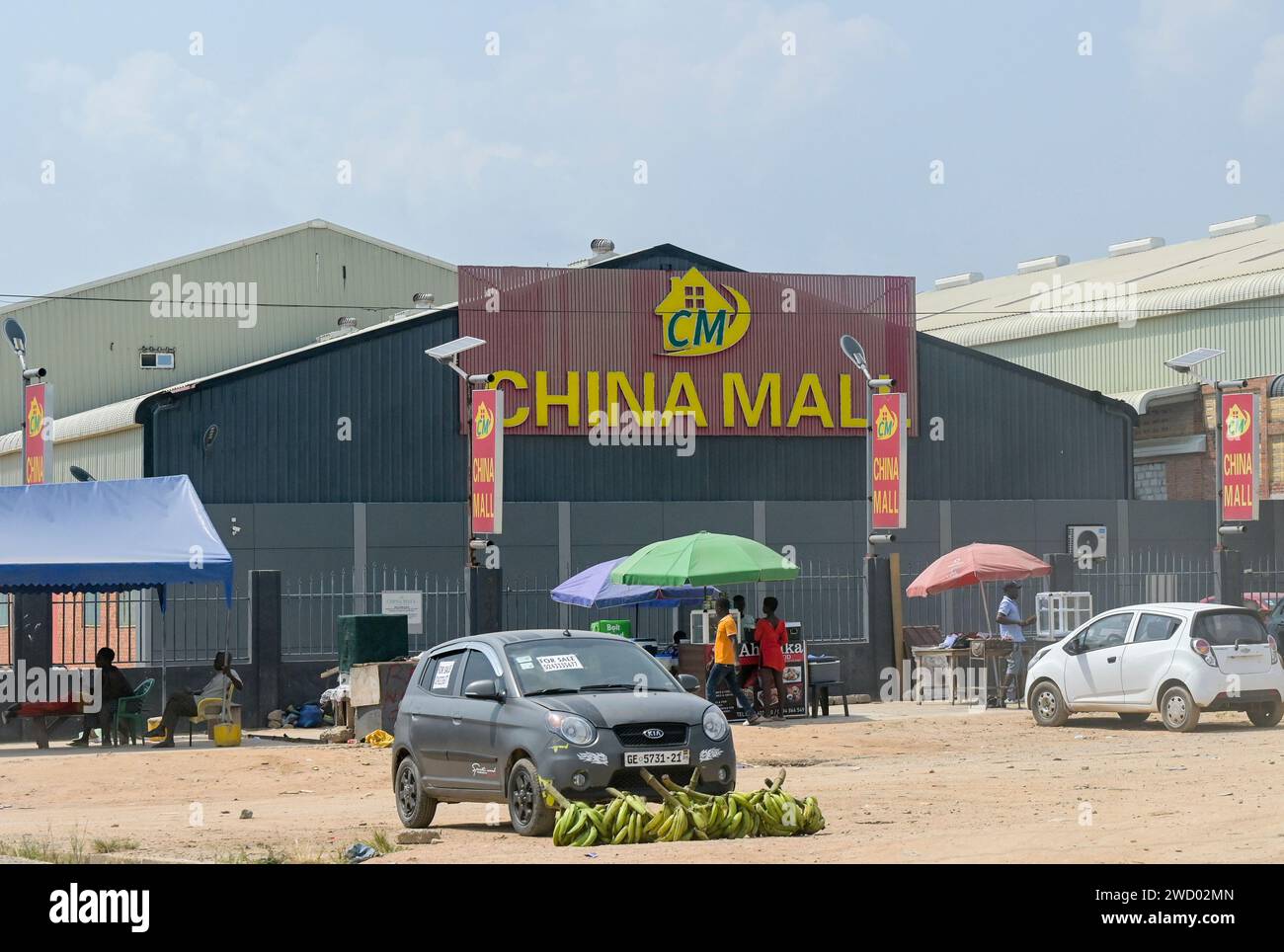 GHANA, chinese owned shopping center China Mall on the Accra - Kumasi Road, in contrast infront local banana seller / GHANA, Einkaufszentrum China Mall an der Accra - Kumasi Autobahn, in Kontrast lokaler Bananenverkauf Stock Photo