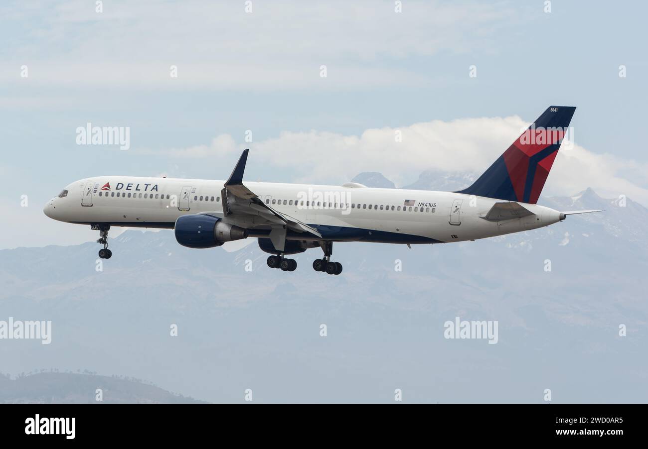 A Delta Airlines airplane soaring by majestic mountain range beneath a