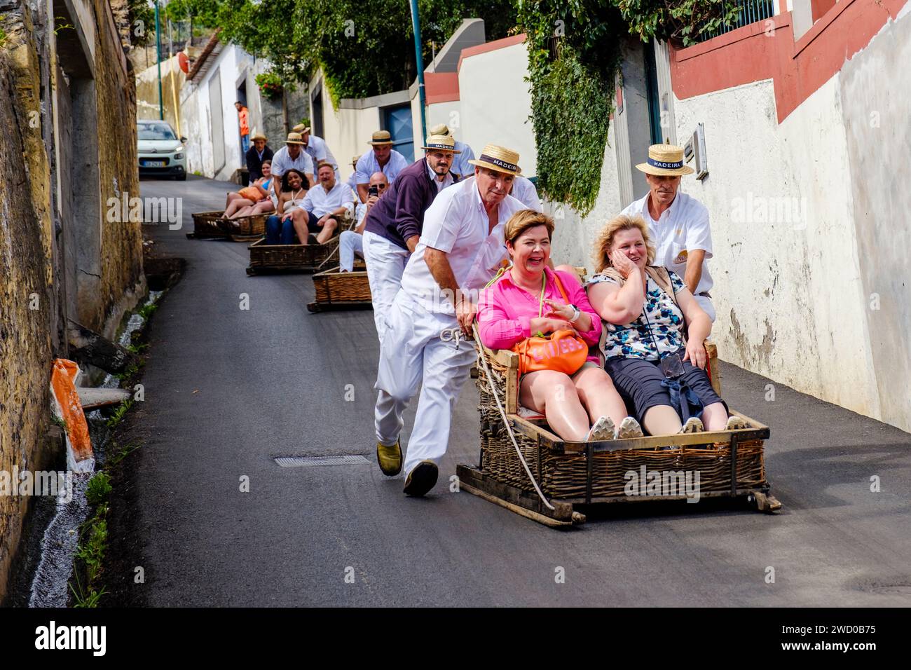 Tourists pushed downhill by carreiros, carros de cesto, basket carts, Monte toboggan ride, wicker basket carts mounted on skids, Funchal, Madeira Stock Photo