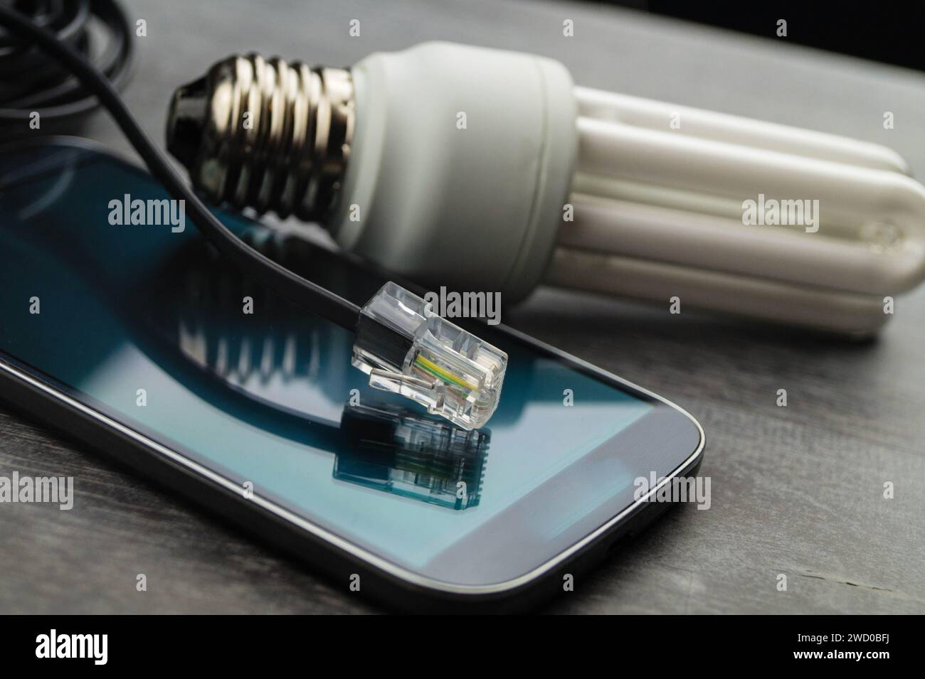 Energy-saving lamp, smart phone and network plug, symbolic image for smart home Stock Photo