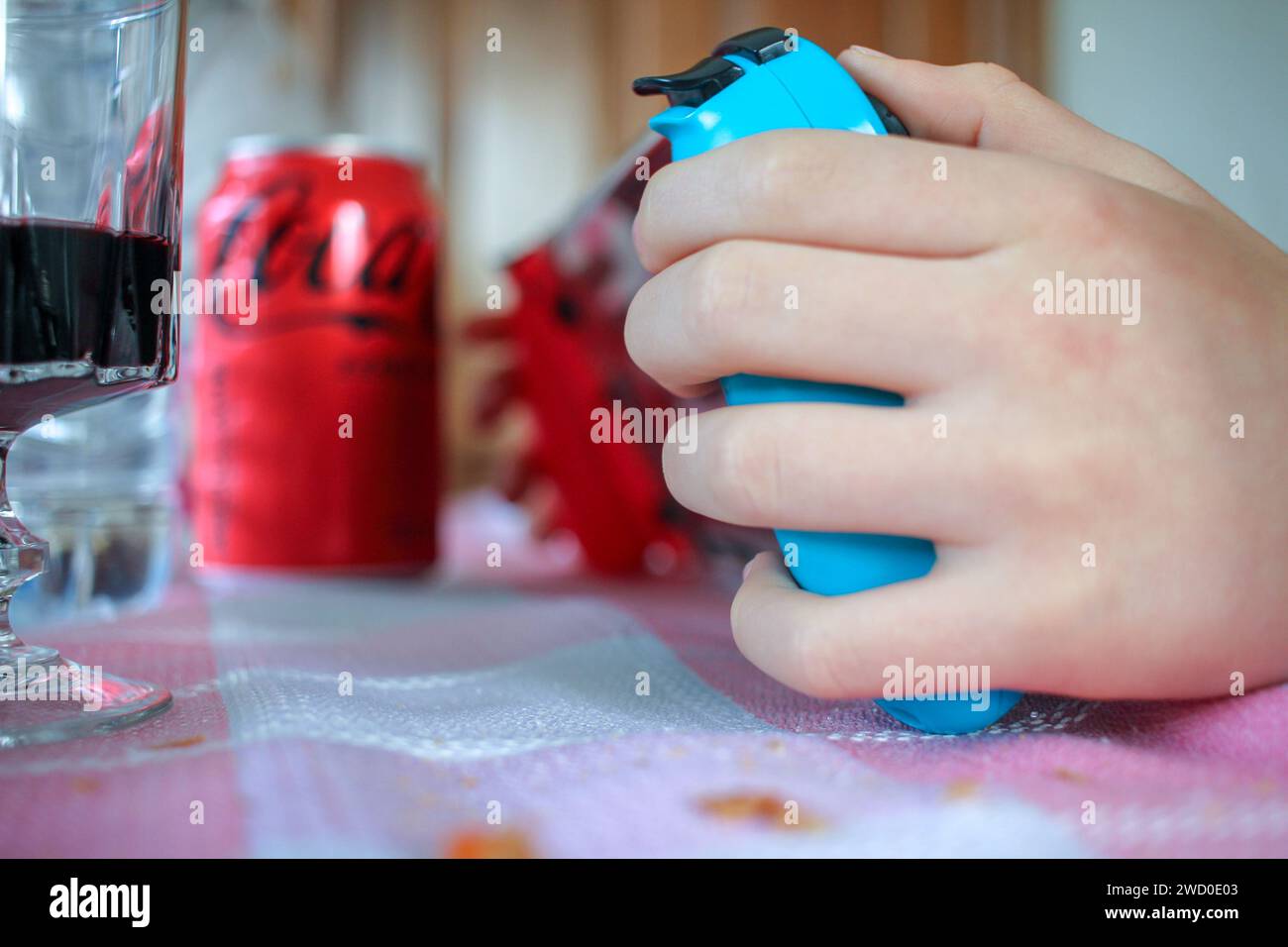 Burela, Spain - 08 08 2023 : young kid playing with a Nintendo Switch and drinking Coke Stock Photo