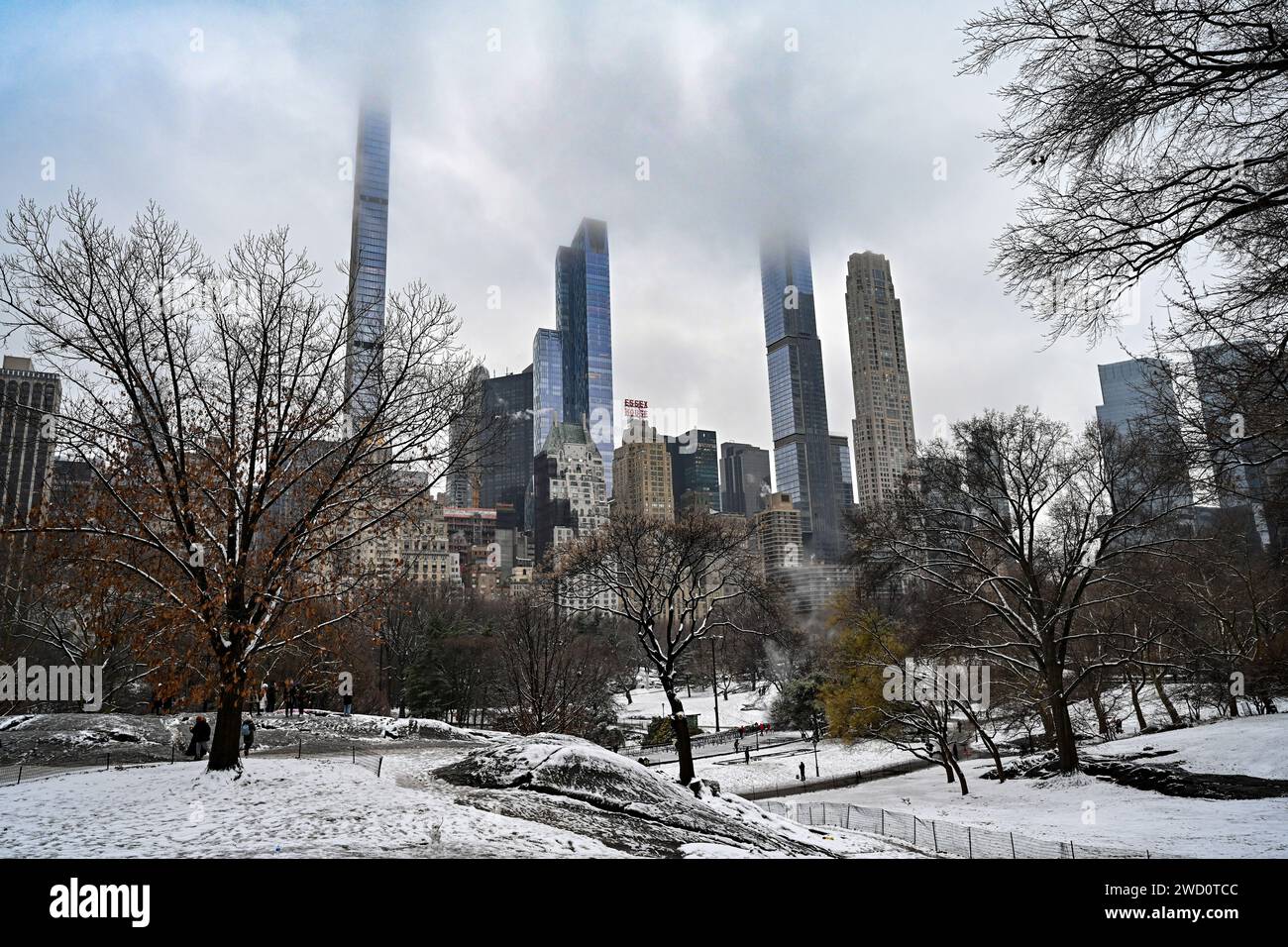 People walk in Central Park as snow blankets New York City breaking a