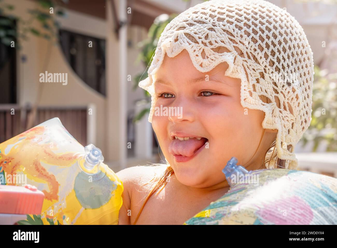Portrait of a cheerful child in oversleeves looking to the side on vacation Stock Photo