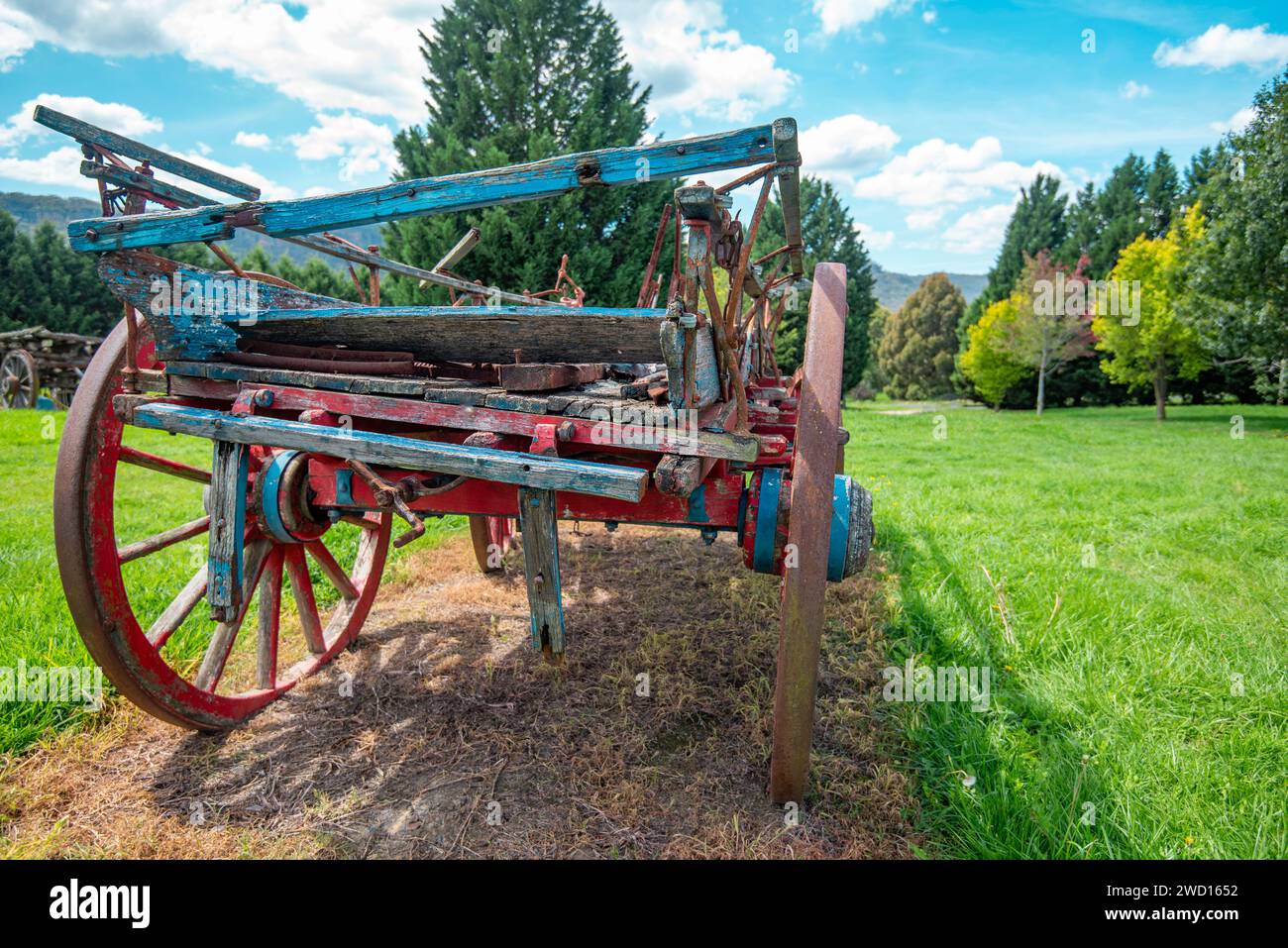A closeup of an old dray or wagon in a grassy paddock in New South Wales, Australia. A relic of early farm transport with steel rimmed wooden wheels Stock Photo