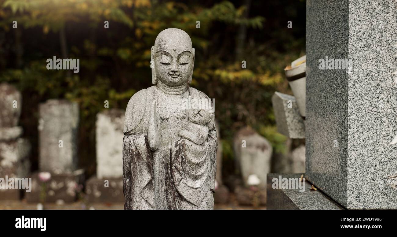 Buddha, statue in Japan graveyard with child for safety, protection and sculpture outdoor in nature. Jizo, tombstone and memorial gravestone with Stock Photo