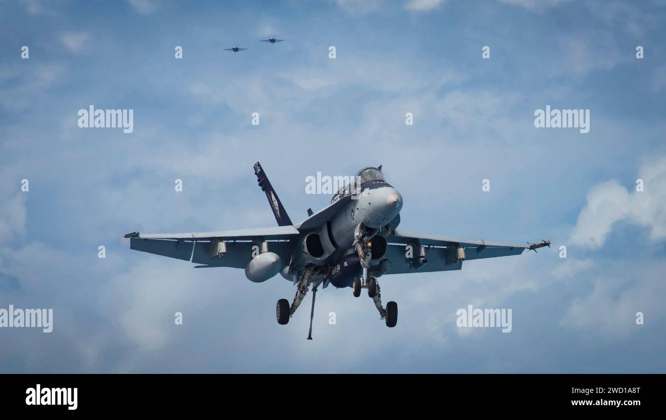 An F/A-18C Hornet prepares to make an arrested landing on USS Carl Vinson. Stock Photo