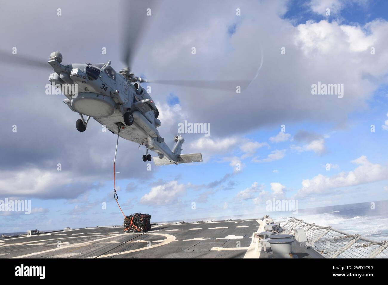 An MH-60R Sea Hawk helicopter conducts a vertical replenishment aboard USS Kidd. Stock Photo