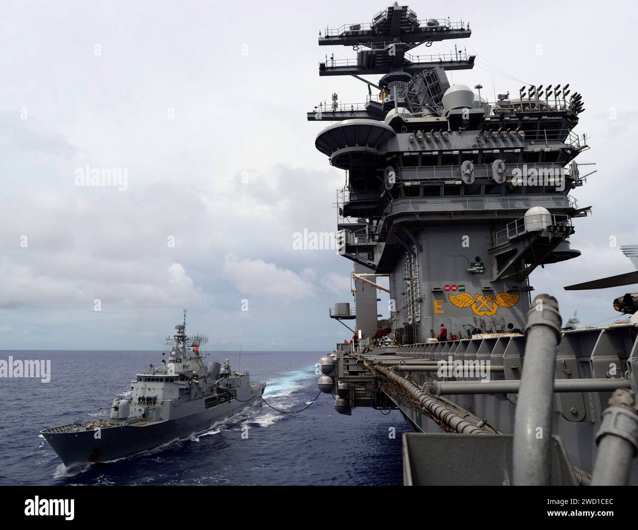 Royal New Zealand Navy frigate HMNZS Te Kaha  conducts a replenishment with USS Nimitz. Stock Photo