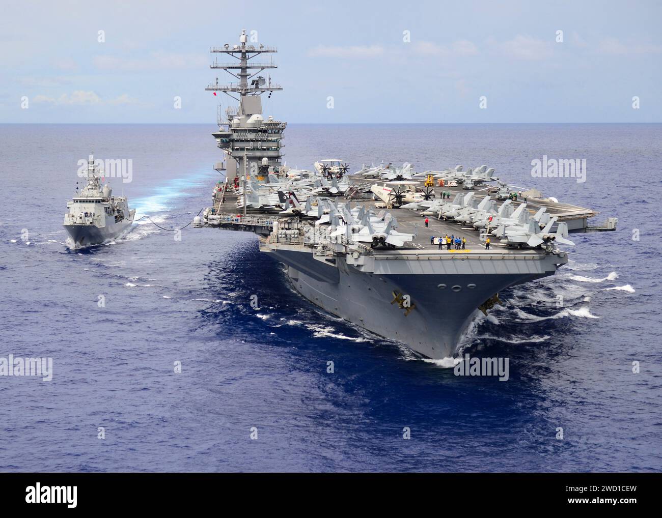 USS Nimitz conducts a replenishment-at-sea with the Royal New Zealand Navy frigate HMNZS Te Kaha. Stock Photo