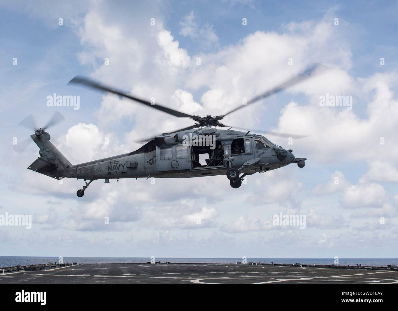 An MH-60S Sea Hawk helicopter takes off from the flight deck of USS Oak Hill Stock Photo