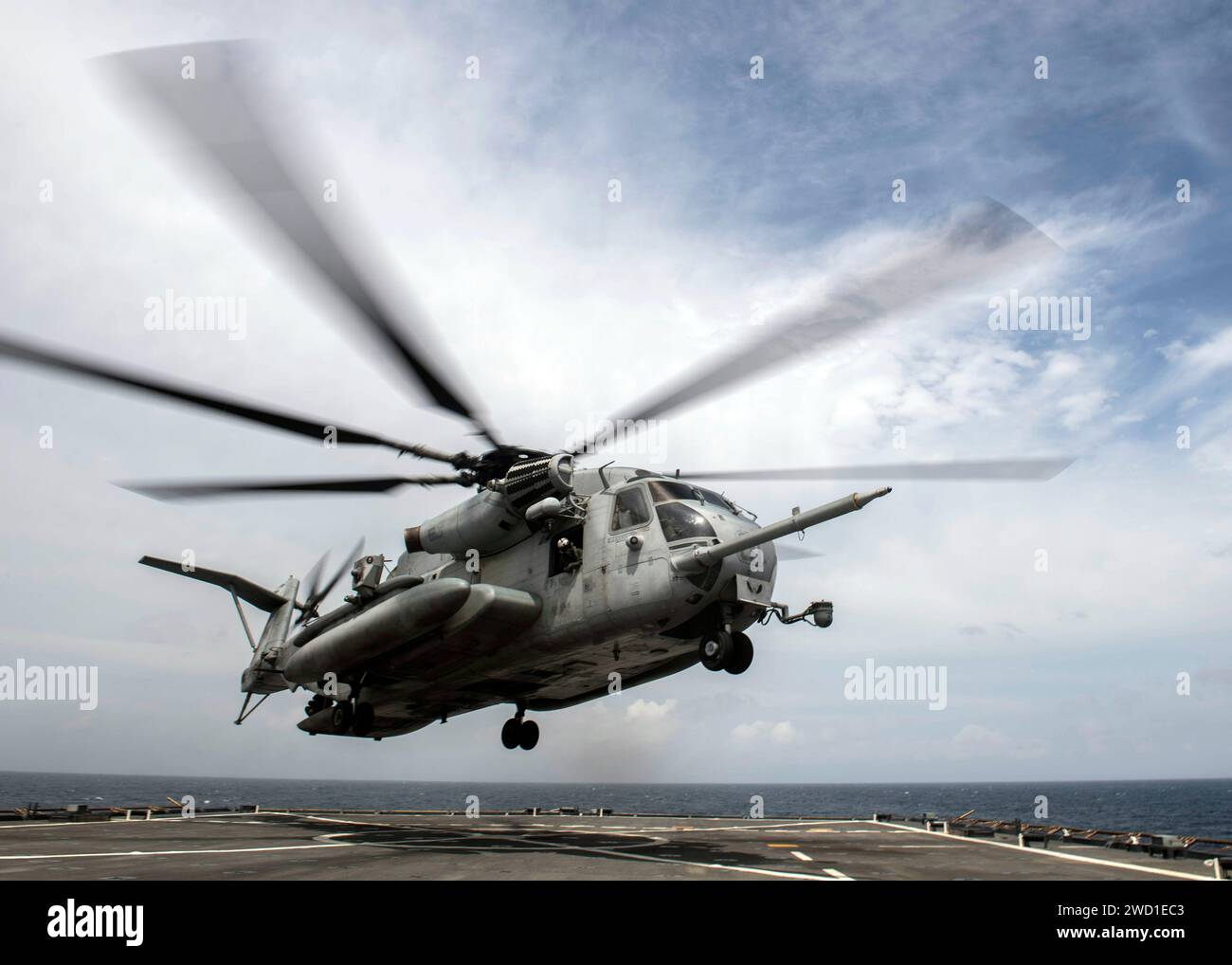 An MH-53E Sea Dragon helicopter lifts off from the flight deck of USS Oak Hill. Stock Photo