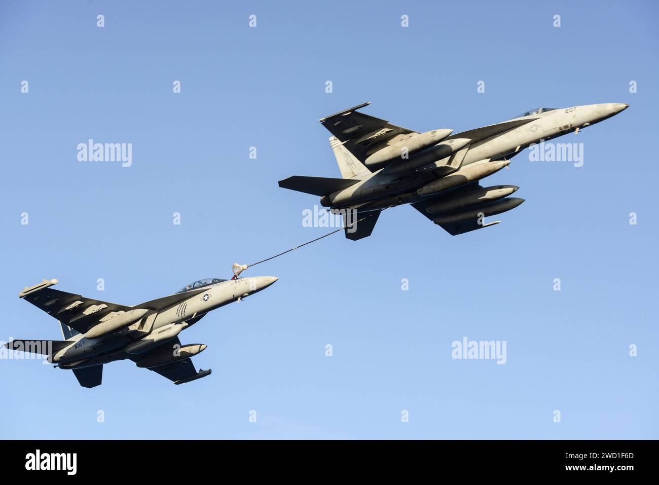 An F/A-18E Super Hornet, right, refuels an EA-18G Growler. Stock Photo