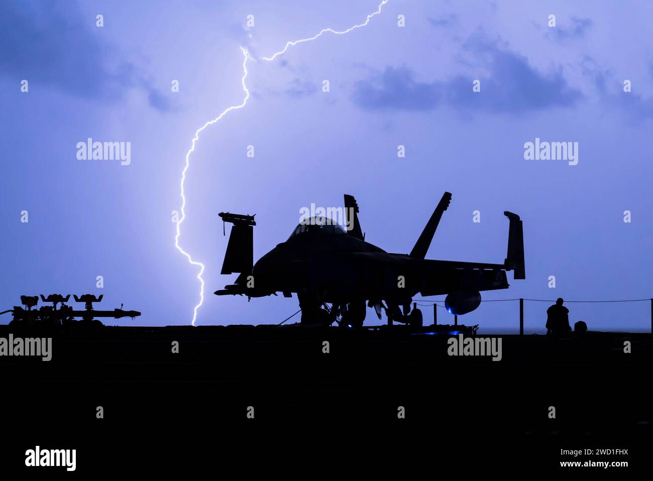 Lightning strikes near the aircraft carrier USS Theodore Roosevelt as it transits the Arabian Gulf. Stock Photo