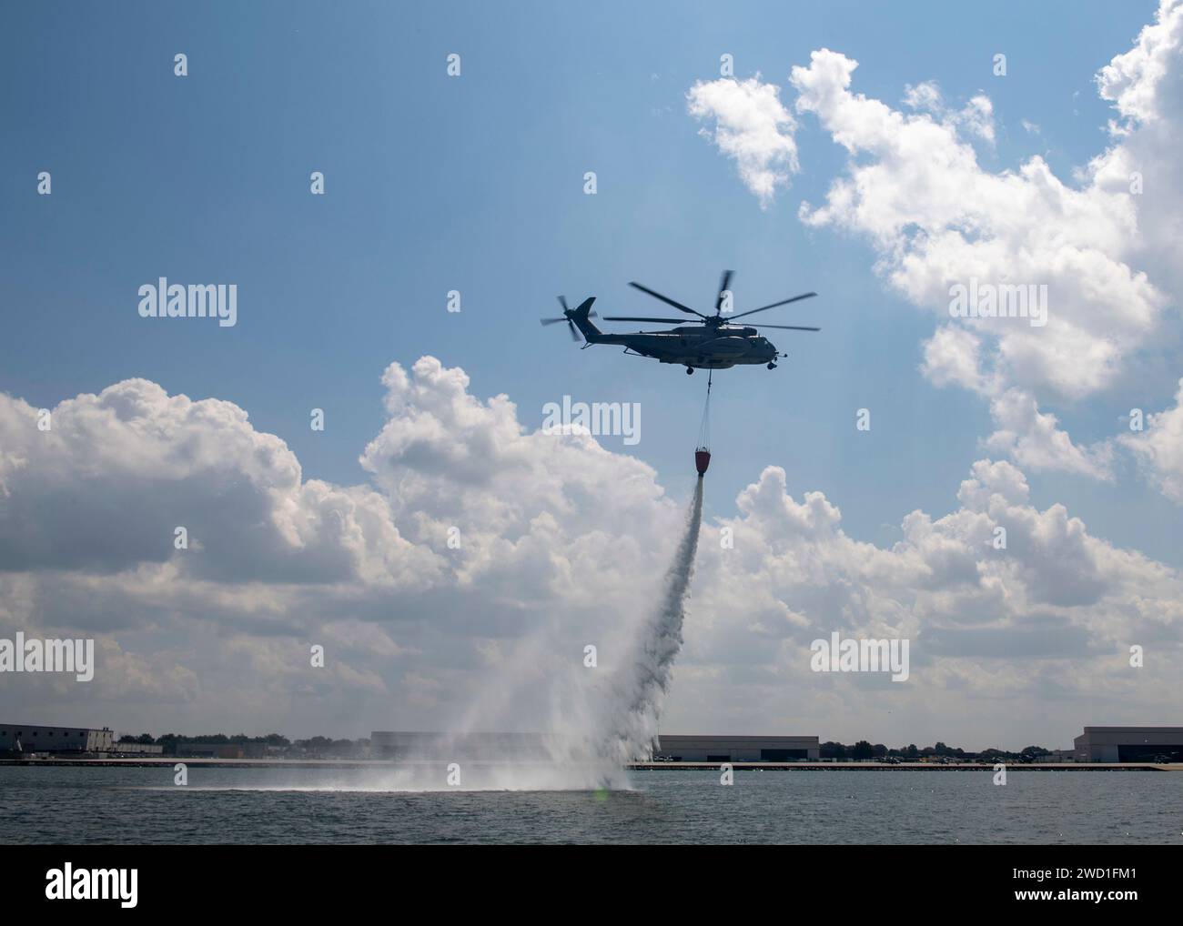 An MH-53E Sea Dragon helicopter performs an aerial firefighting training exercise. Stock Photo