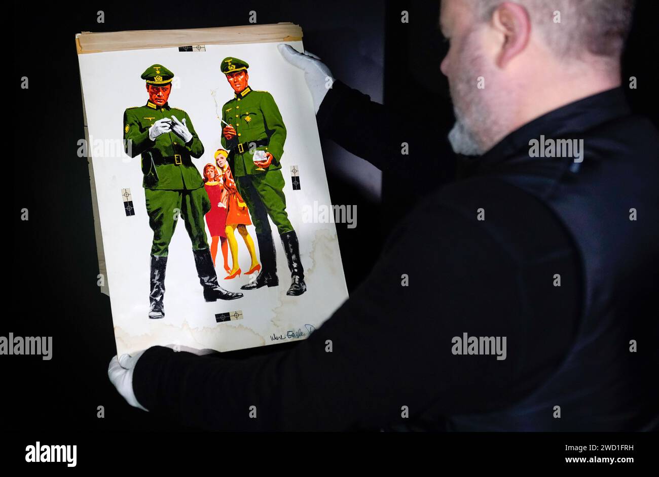 Propstore poster consultant Mark Hochman looks at a photo mockup on artboard for insert and three sheet layout, for the 1968 film 'Where Eagles Dare' (estimate £2,000 - £4,000) during a preview for Propstore's UK poster auction at the Propstore in Rickmansworth, Hertfordshire. Picture date: Wednesday January 17, 2024. Stock Photo