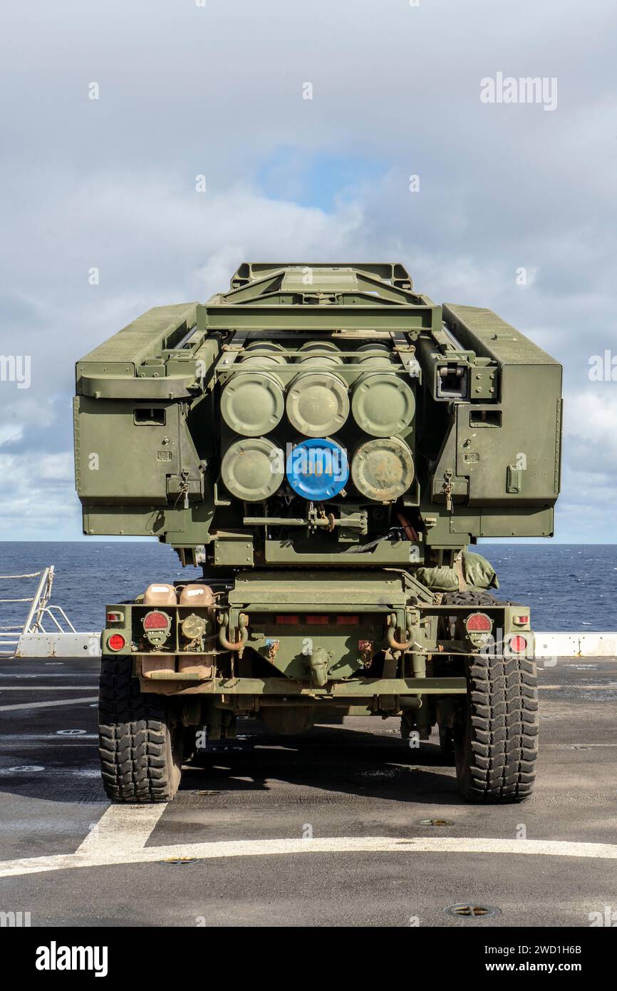 U.S. Marines position a HIMARS vehicle on the flight deck of a ship. Stock Photo